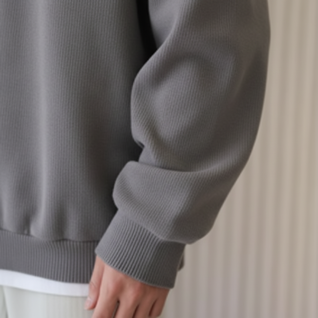 Detalle manga jersey gris con textura acanalada sutil